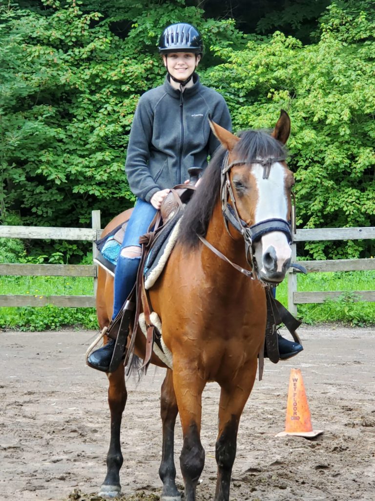 girl in riding gear posing on horse