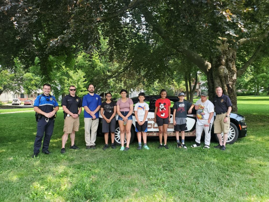 kids posing with rome police department officers in park